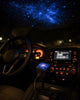 Portrait format 4:5 photograph. Interior of a car at night. The Galaxy projector PROj is plugged int